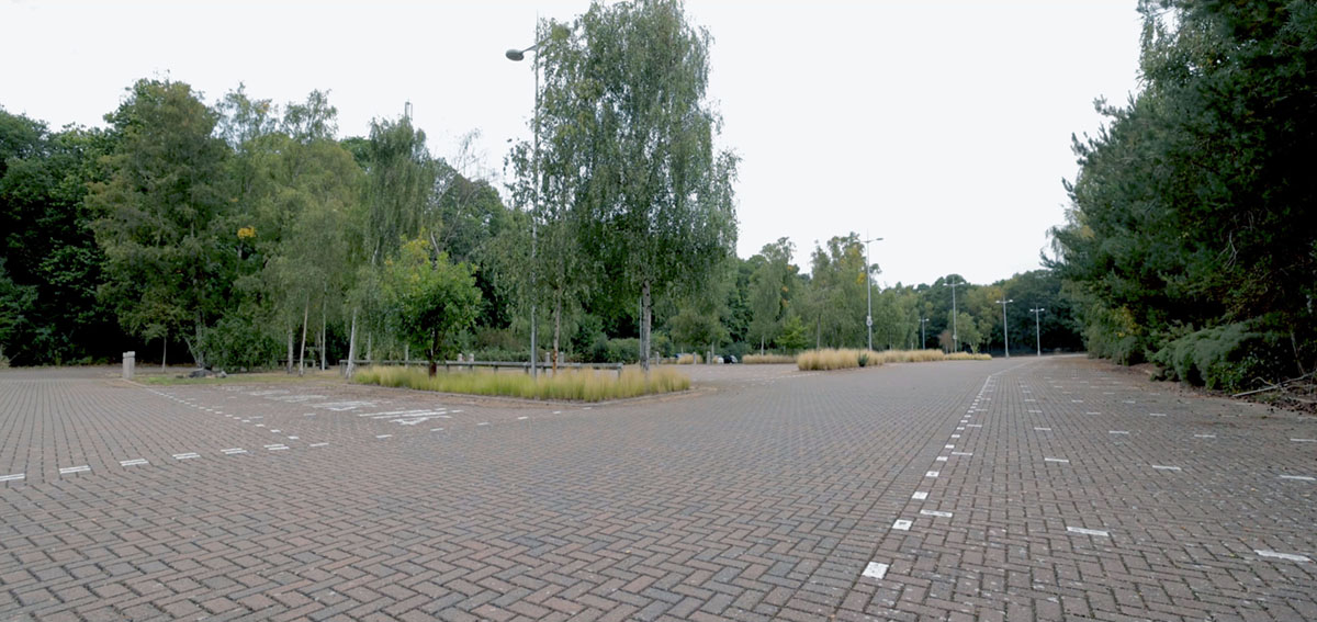 A photo showing Martlesham Park & Ride carpark with paving, trees and landscaping.